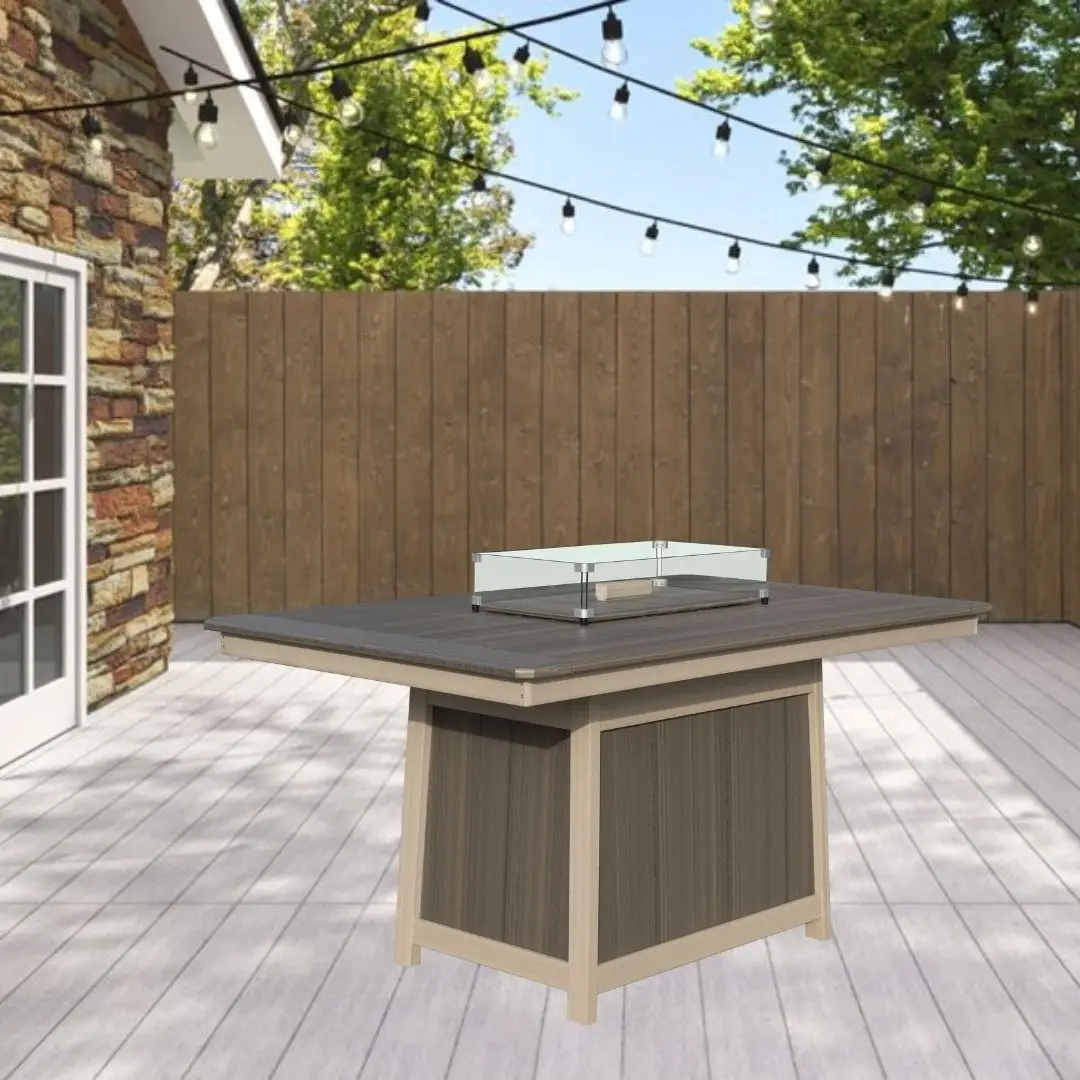 Outdoor backyard scene with a square fire pit table on a light deck, string lights overhead, wooden fence in the background.