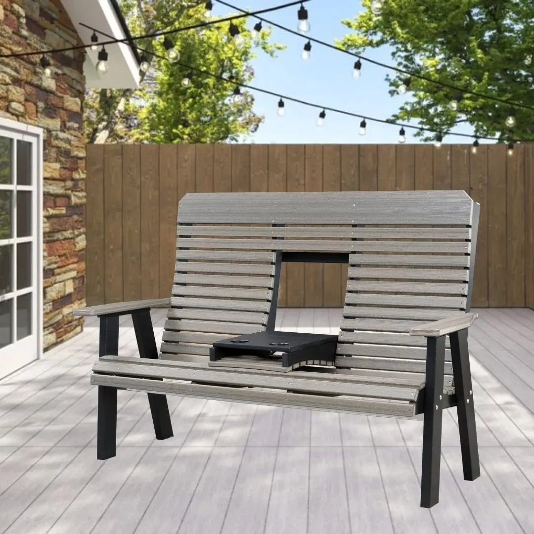 Outdoor wooden two-person bench swing on a patio with string lights above and a wooden fence in the background.